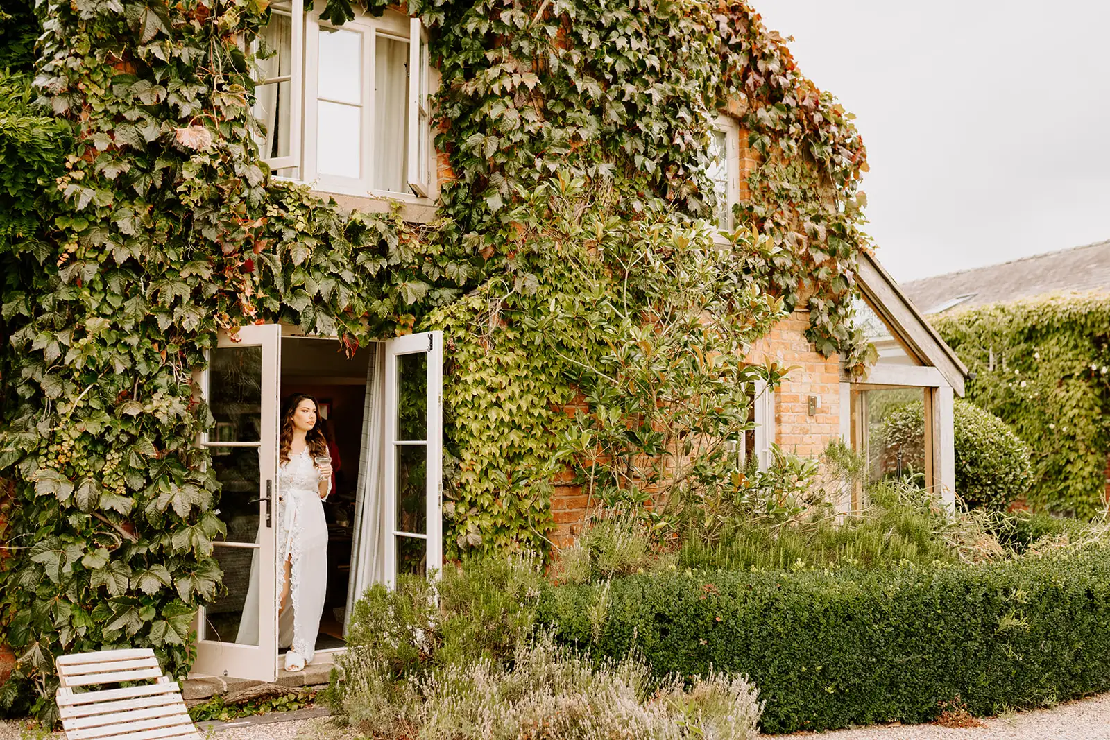 Bride standing in open doors at private estate wedding venue in the UK