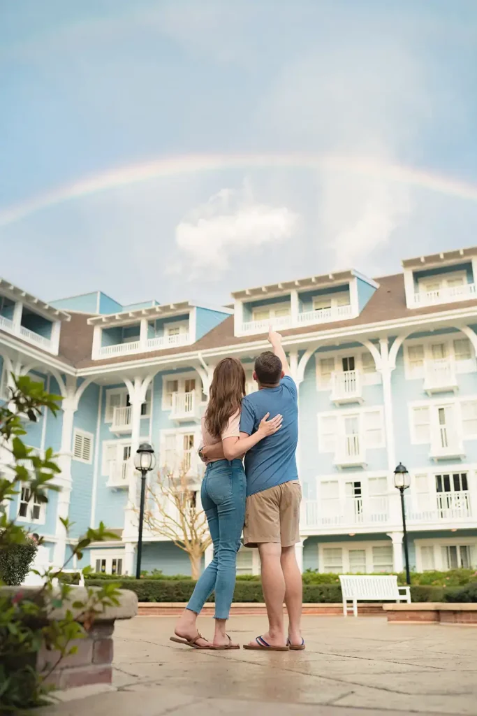 couple looks at a rainbow over Disney Boardwalk