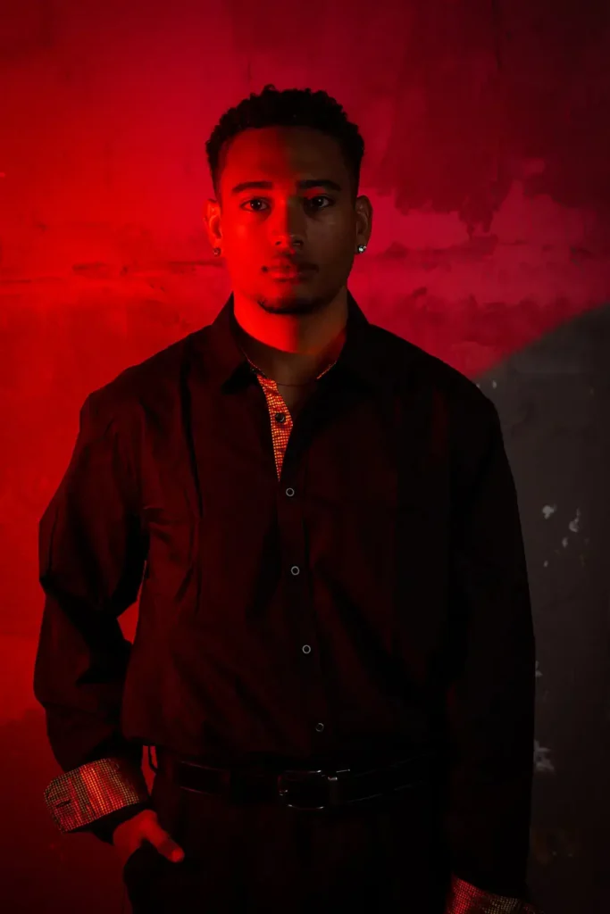Senior photo of young man with read lighting