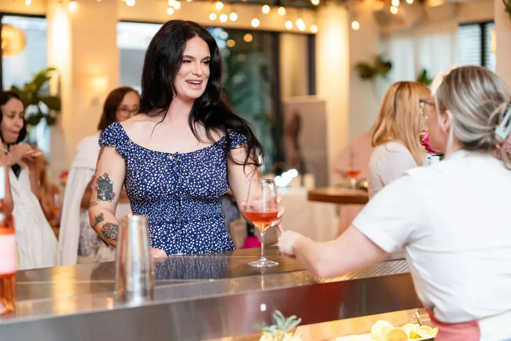 Woman getting Rose drink from bartender