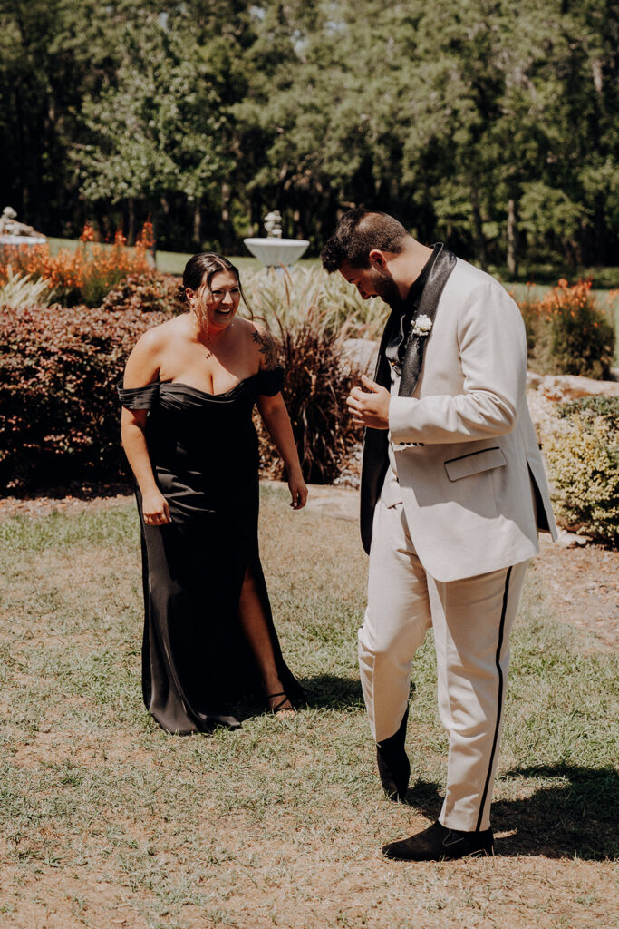 groom shows off wedding day suit to sister