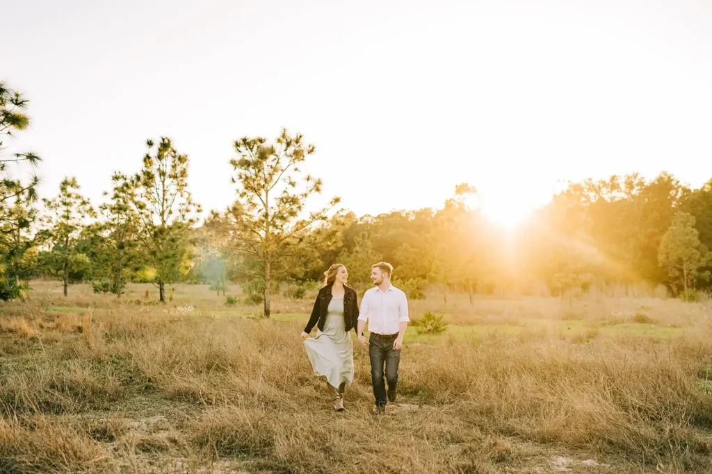 Couple walks through field in Clermont, FL for engagement photo