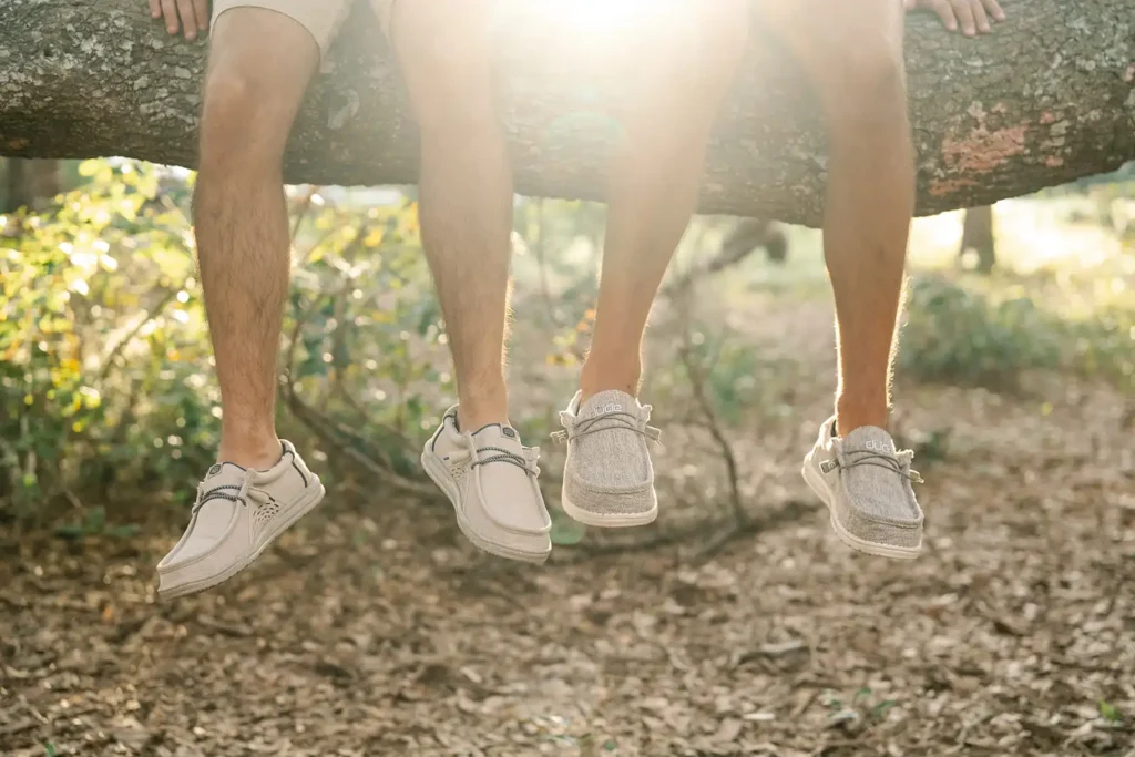 Two pairs of feet hanging from a tree limb