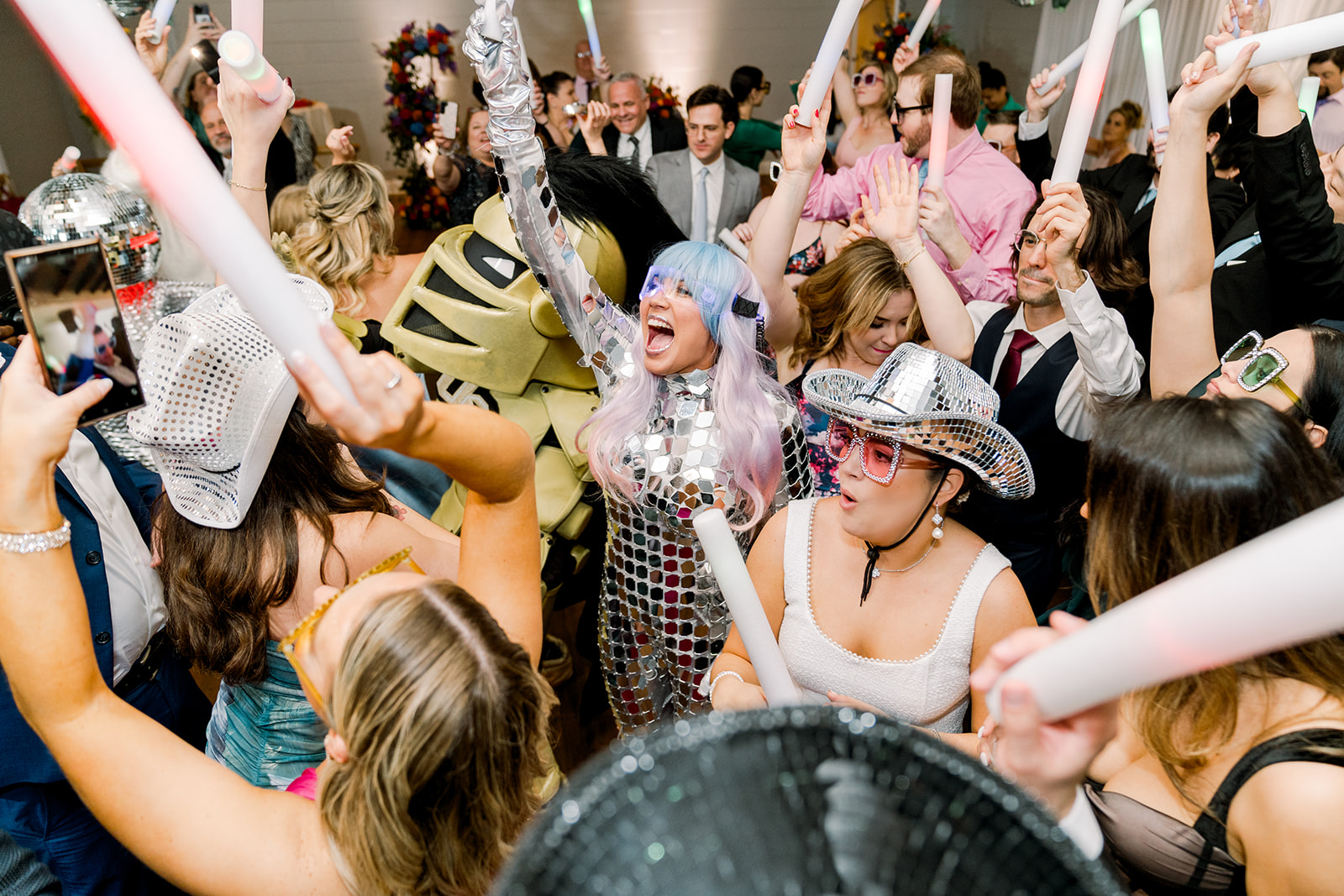 Wedding guests pack the dance floor with light up wants, Nitro from UCF and disco hats