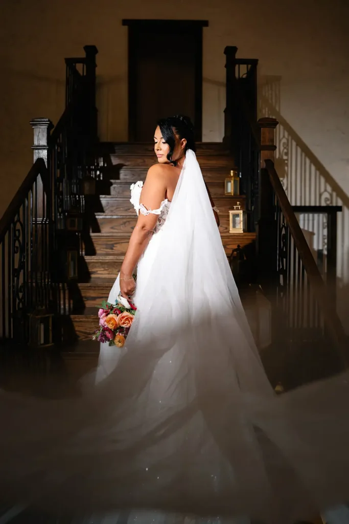 Bride looks over shoulder while climbing stairs at Sterling Event Venue, FL