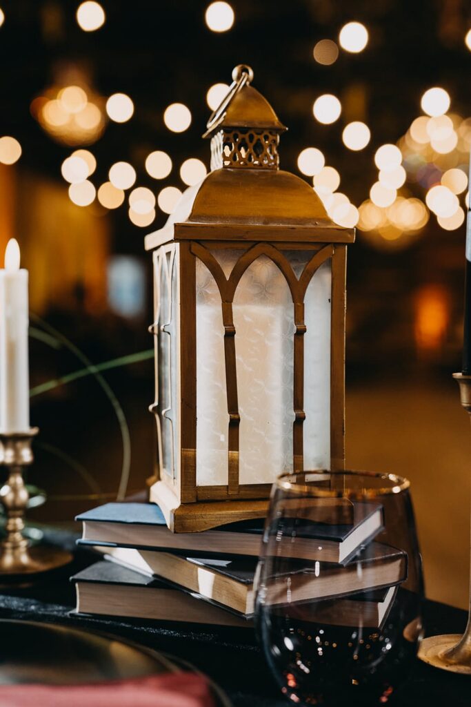 Gold lantern on a stack of books as wedding reception centerpiece