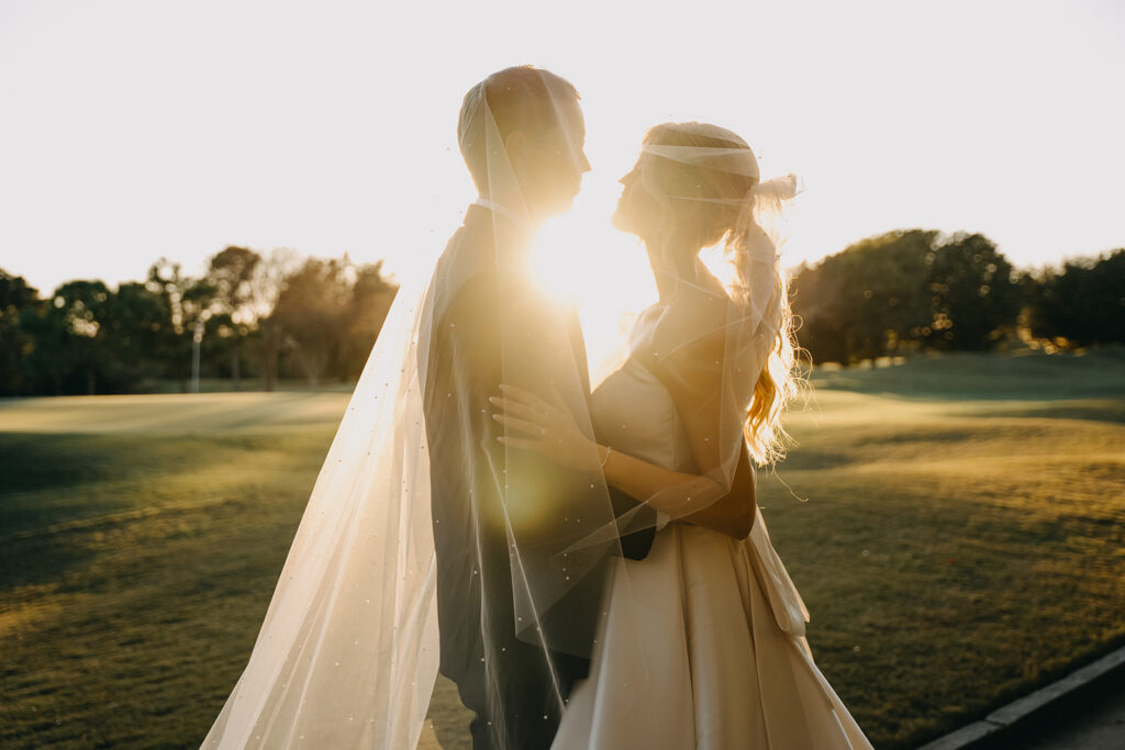 Bride and groom facing each other at sunset on golf course at Rosen Shingle Creek