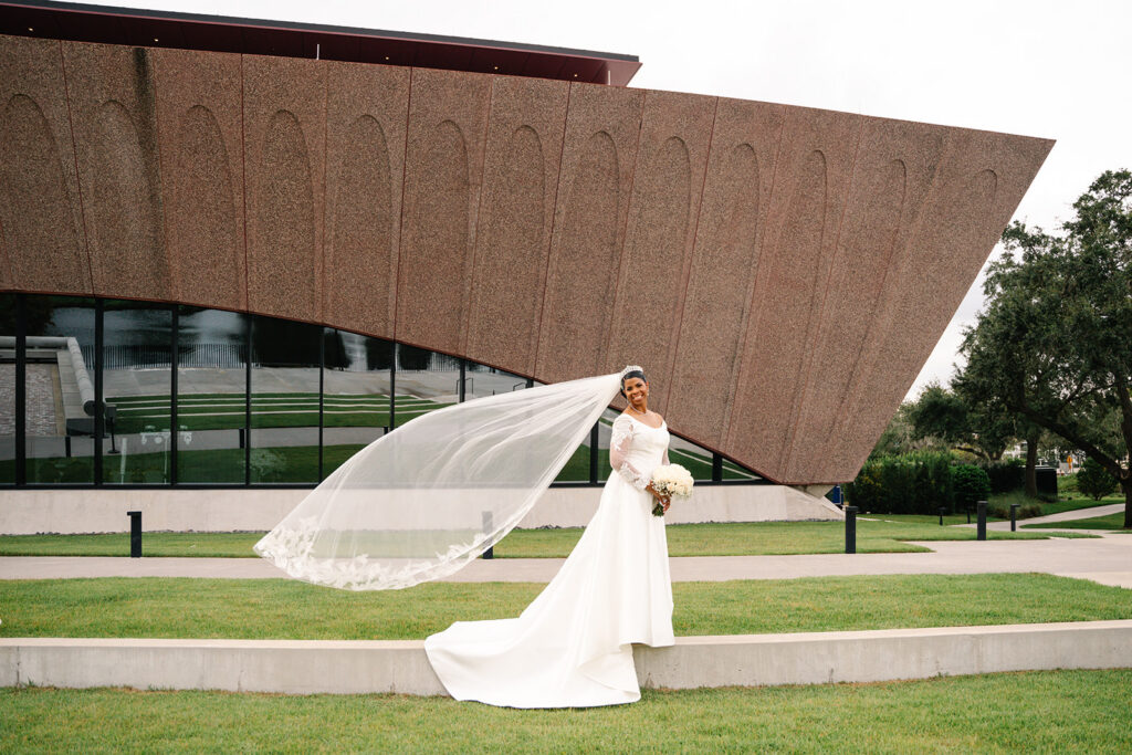 Bride with veil blowing in the wind outside the Winter Park Event Center