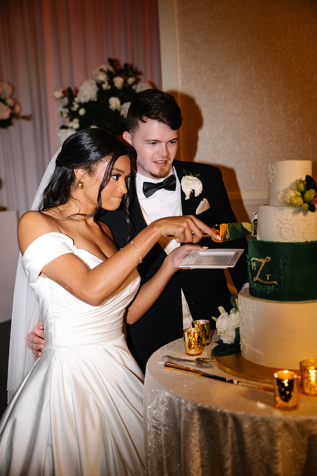 Bride making funny face while cutting wedding cae